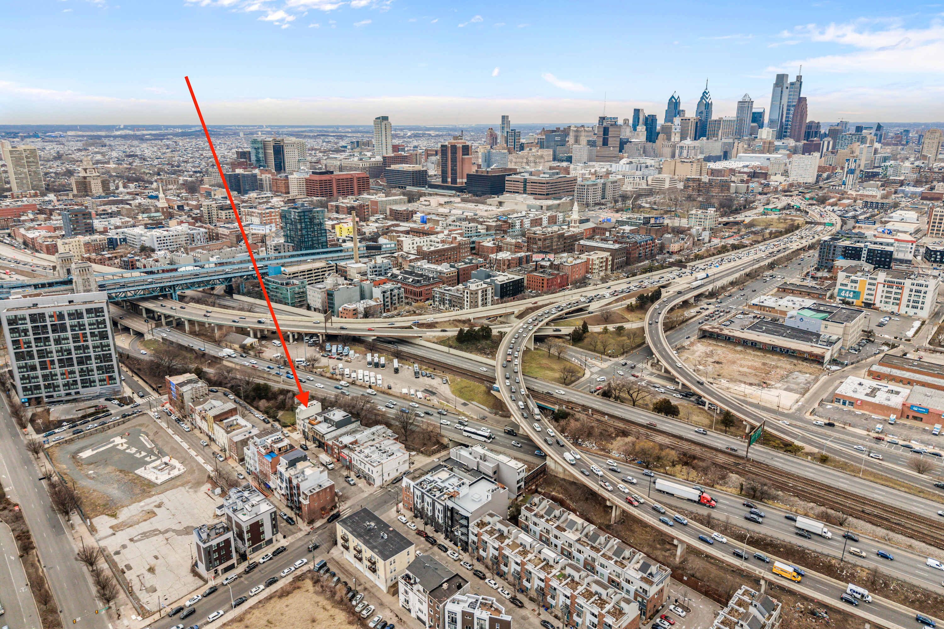 An aerial view of a cityscape with a prominent bridge, multiple highways, and a dense urban environment.