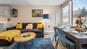 Een moderne woonkamer met een bank, salontafel en een eethoek.