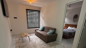 A modern living room with a sofa, coffee table, and a ceiling fan. - Tranquil 2-bedroom apartment with AC in welcoming Tulum (Tulum)