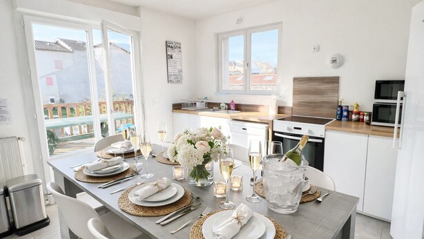 A modern kitchen with a dining area set for a meal.