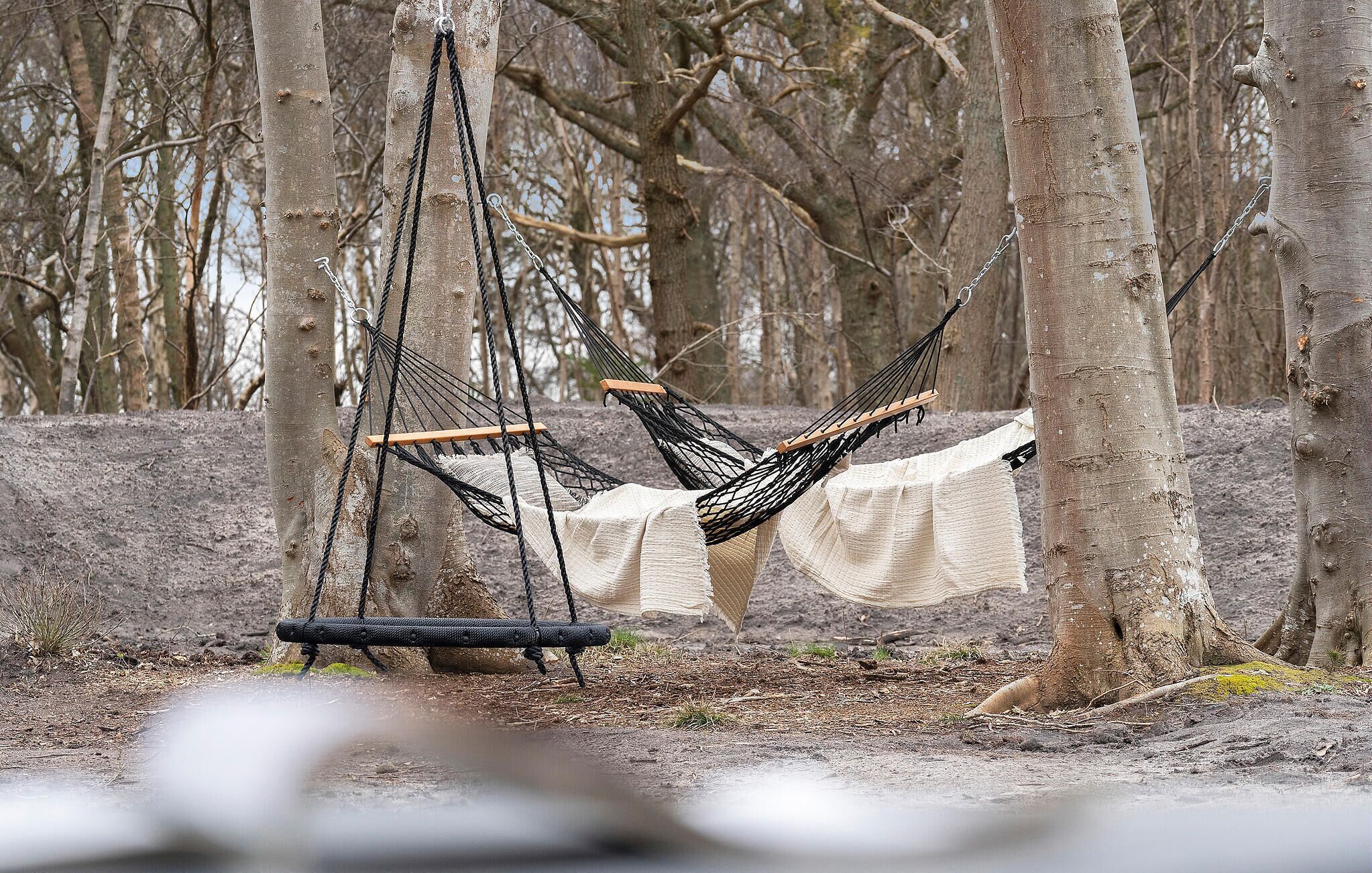 Un hamac suspendu entre des arbres, dans un cadre naturel.