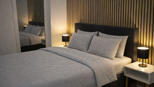 Une chambre moderne avec un grand lit, deux tables de chevet et un mur recouvert de lambris en bois verticaux.