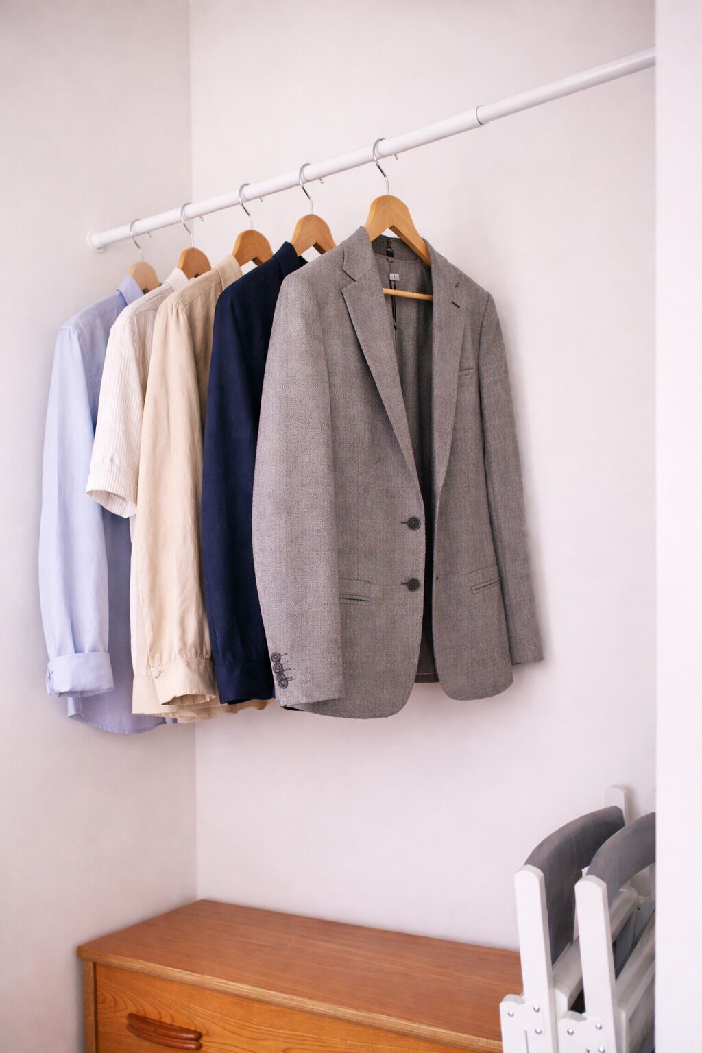 A clothing rack with various blazers and shirts.