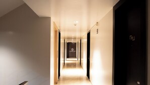 A hotel corridor with a sign for Everest Inn, a long hallway with doors on both sides, and a lighted floor. - Everest Inn Chakan (Chakan)