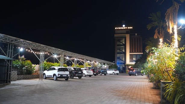 A parking lot with multiple cars and a building labeled 'Everest Inn' in the background. - Everest Inn Chakan (Chakan)