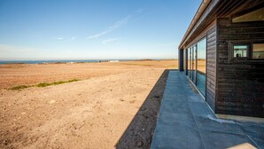 Un bâtiment doté d’un long et étroit porche donnant sur un vaste champ dégagé.