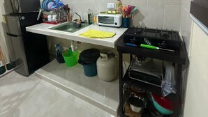 A compact kitchen with a refrigerator, microwave, sink, and gas stove. - Casa Villas Amanecer only 5 minutes away from Merida's periferico (Kanasín)