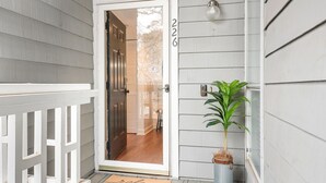 A house entrance with a white door, a number '226' on the wall, and a potted plant on the porch. - Sunrise Cove on Lake Norman (Davidson)
