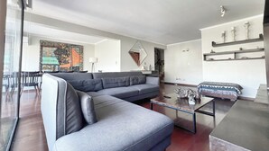 Una sala de estar moderna con un sofá modular, una mesa de centro y un comedor con sillas.