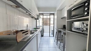 Una cocina moderna con electrodomésticos de acero inoxidable, encimera de madera y vistas al exterior.