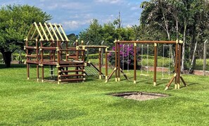 A playground with a wooden climbing structure and swings. - Lindísimo TopSpot® para 20 a 15 min de Armenia! (Armenia)