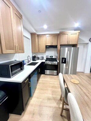 A modern kitchen with wooden cabinets, stainless steel appliances, and a white countertop. - Urban Pulse:4b4b 15 min to Sofi Stadium, DTLA, LAX and the Beach (Culver City)