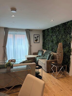 Ein modernes Wohnzimmer mit einer Couch, einem Glastisch und einer Zierdekorvase.