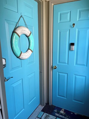 A blue door with a metal handle, a numeric keypad lock, and a life ring hanging on the door. - Large Condo, 2 Floors, POOL Access, 1mile to beach (Myrtle Beach)