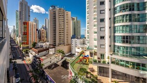 A high-rise building with multiple balconies, a playground, and a clear view of the surrounding cityscape. - Comfort and Convenience 350 Meters From the sea in Balneario Camboriu - Rlps (Balneário Camboriú)