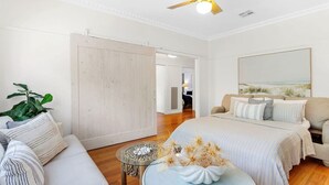 A bedroom with a bed, a sofa, a coffee table, and a large window. - Pet Friendly - Waves on Rye by Property Mums (Rye)