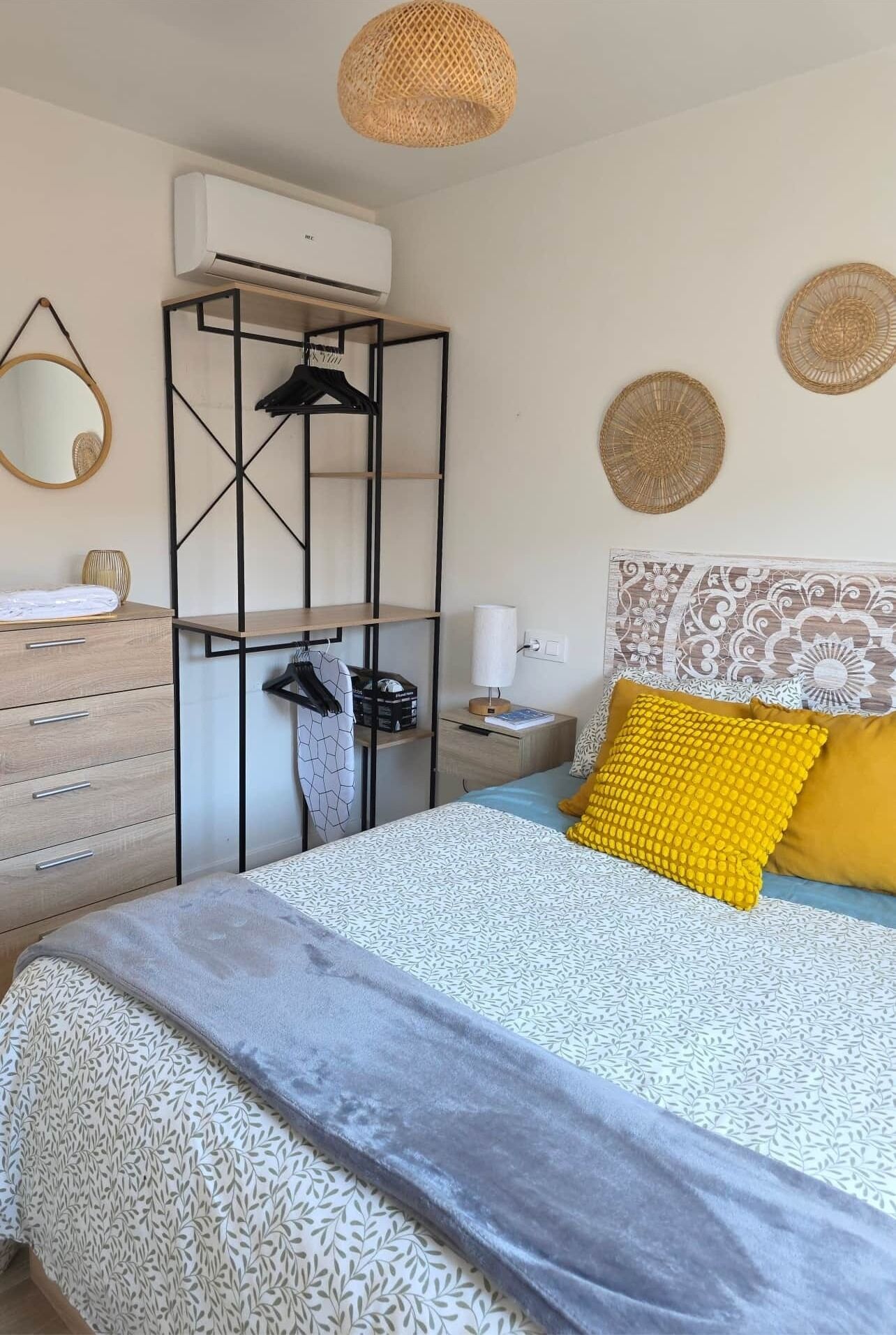 A neatly arranged bedroom with a bed, bedside table, and a wardrobe.