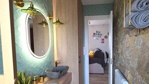 A bathroom with a modern vanity, a large mirror, and a stone sink. - ALMAVERA. Pure Calm House. Colibri 1 Apartment (Madrigal de la Vera)