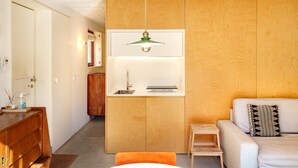 Un interno moderno con una parete divisoria in legno, un divano bianco, un piccolo tavolino e una lampada a sospensione.
