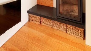A modern interior with a built-in wood-burning stove, wooden flooring, and a staircase. - VIVA - Lage Serviced Apartments 29 (Porto)