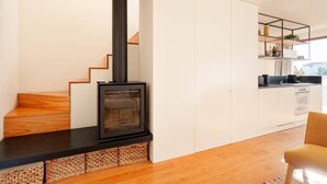 A modern kitchen with a black stove, wooden staircase, and white cabinets. - VIVA - Lage Serviced Apartments 29 (Porto)