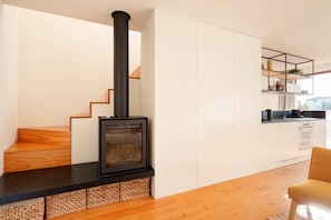 A modern kitchen with a black stove, wooden staircase, and white cabinets. - VIVA - Lage Serviced Apartments 29 (Porto)