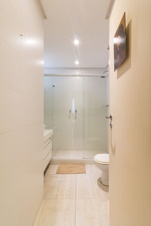 A modern bathroom with a glass-enclosed shower, a toilet, and a sink. - Stunning View of Sugarloaf Mountain - Pb1201 (Rio de Janeiro)
