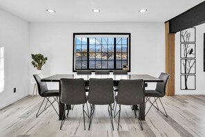 Une salle à manger moderne avec une grande fenêtre, une table à manger et quatre chaises.
