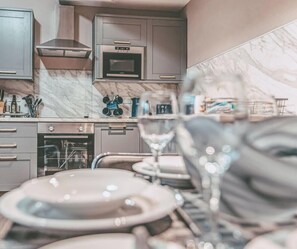 A modern kitchen with grey cabinets, a microwave, and a stove. - Kingsley Loft – Stylish City Apartment in Central Chester | Sleeps 6 (Chester)