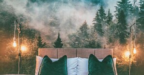 A bed with a wooden headboard, green and white pillows, and a view of a forest through a window. - Kingsley Loft – Stylish City Apartment in Central Chester | Sleeps 6 (Chester)