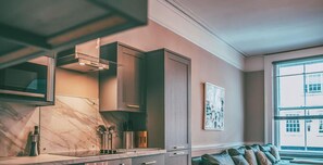 A modern kitchen with a built-in stove, cabinets, and a window with a view. - Central Vista Retreat | Modern City Centre Apartment | Sleeps 6 (Chester)