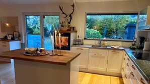 Een moderne keuken met een groot kookeiland, witte kasten en een decoratie van een hertenschedel.