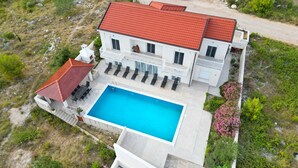 A two-story house with a swimming pool, outdoor seating, and a red-tiled roof. - Villa Katarina 5-bedroom near Dubrovnik with private pool (Ivanica)