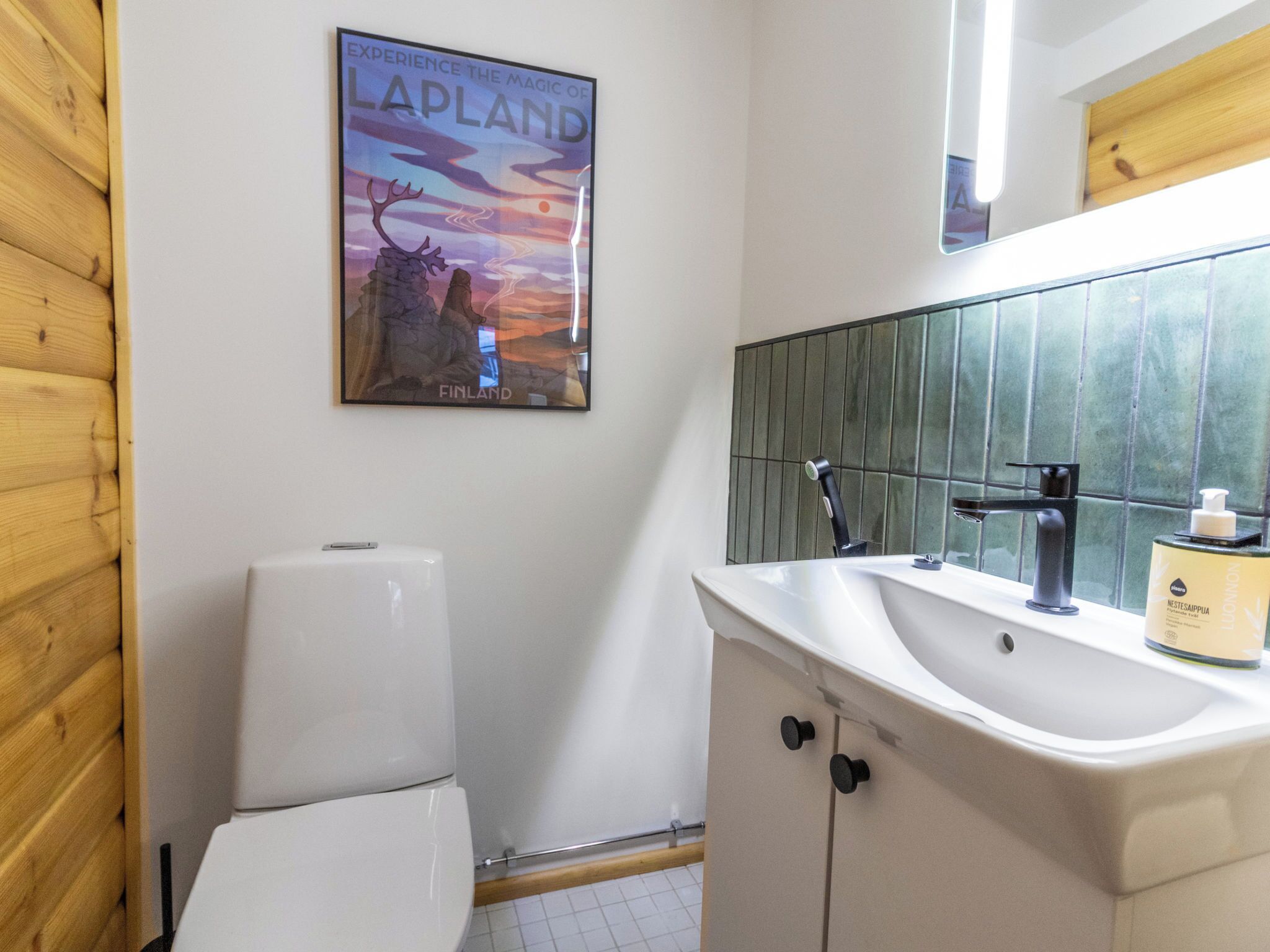 Un baño con inodoro, lavamanos y un cartel de Laponia.