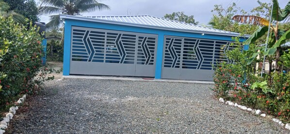 Un edificio con fachada azul y camino de grava.