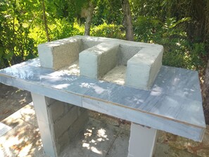 Une structure en béton, dotée d’un sommet plat et d’une base rectangulaire, entourée de verdure.