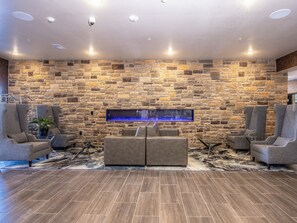 Een moderne lounge met stenen muren, een groot aquarium en comfortabele zitplaatsen.