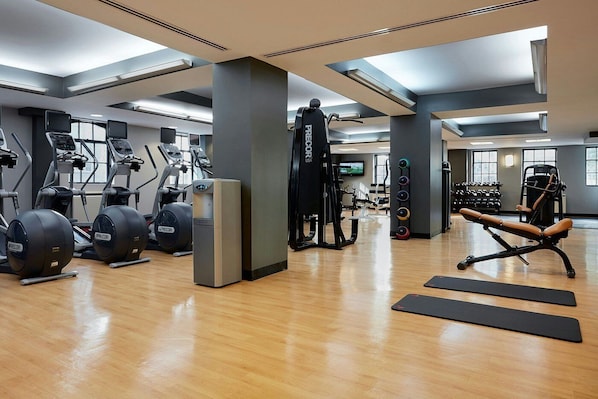 A gym with various exercise equipment, including treadmills, elliptical machines, and weight machines.