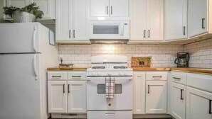 A kitchen with white cabinets, a stove, and a microwave. - Tuscan Inspired 3br Cottage (Lebanon)