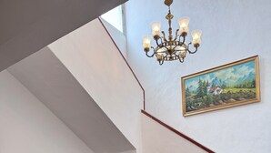 Una sala de estar con televisión, sofá, mesa de comedor y escalera.