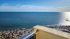 A beach with umbrellas and lounge chairs, a pier, and a clear view of the sea. - Experience a fantastic stay at Dolce Vita apartment, right next to the beach! (Durrës)