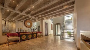 A spacious interior with exposed wooden beams, a staircase, and a large mirror. - ¡Nuevo TopSpot®! Dúplex PH en el corazón histórico (Cartagena de Indias)