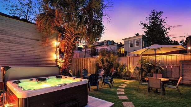 A backyard with a hot tub, outdoor seating, and a wooden fence. - 4 Bedrooms/Hot Tub/3 Parking Spaces/Luxury (Savannah)