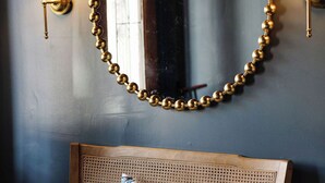 A room with a round mirror, two wall-mounted lamps, and a wooden bench with a cushion. - 4 Bedrooms/Hot Tub/3 Parking Spaces/Luxury (Savannah)