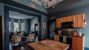A kitchen with wooden cabinets, a stove, and a dining table with a plate. - 4 Bedrooms/Hot Tub/3 Parking Spaces/Luxury (Savannah)