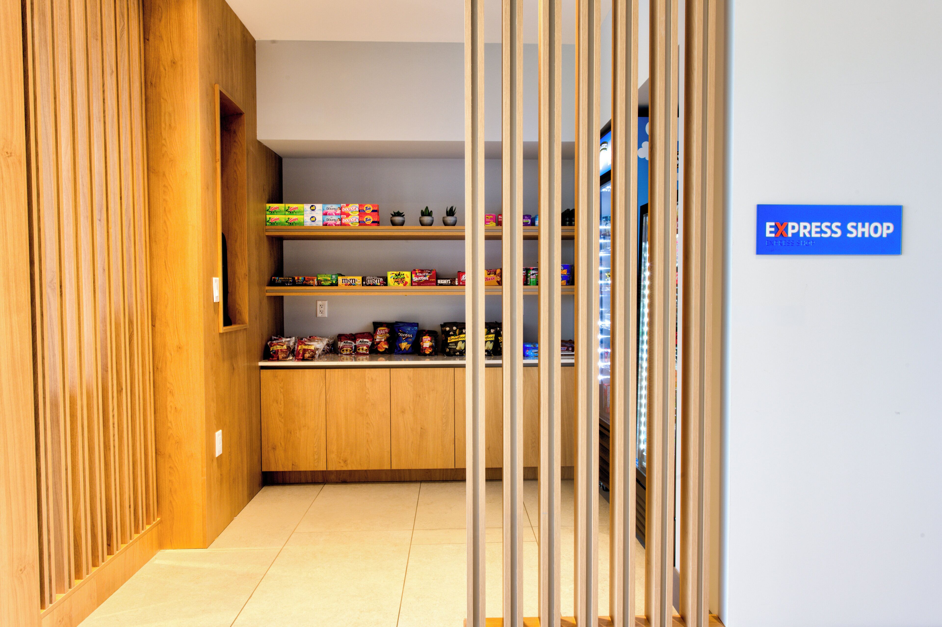 A narrow hallway with wooden paneling on the left and a blue sign reading 'EXPRESS SHOP' on the right.