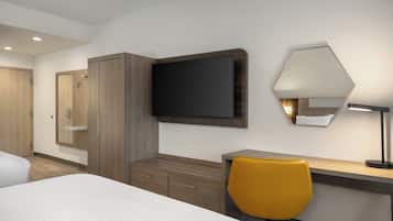 Habitación de hotel con cama, escritorio, silla, armario, televisión de pantalla plana y lámpara.