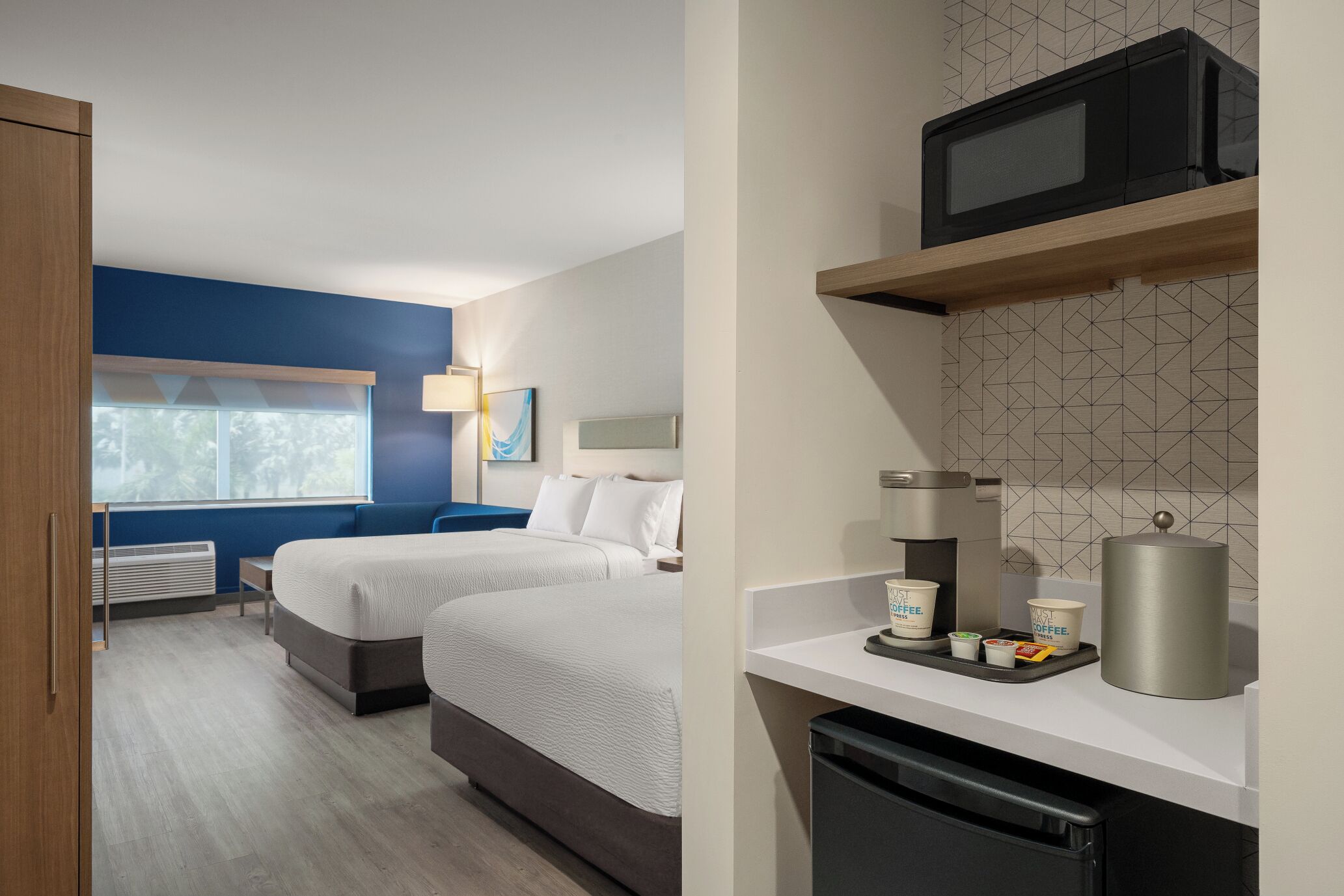 Ein Hotelzimmer mit zwei Betten, einer Mikrowelle, einer Kaffeestation und Blick ins Freie.