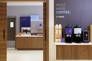 Una estación de café con máquinas de espresso y un letrero que dice 'NECESITO CAFÉ'.