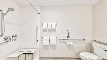 A modern bathroom with a shower, toilet, and sink.